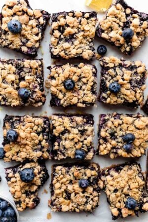 overhead photo of blueberry bars with crumble topping arranged on parchment paper.