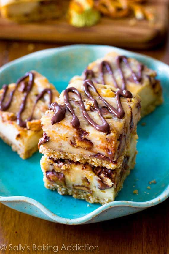 peanut butter cup pretzel cheesecake bars on a teal plate