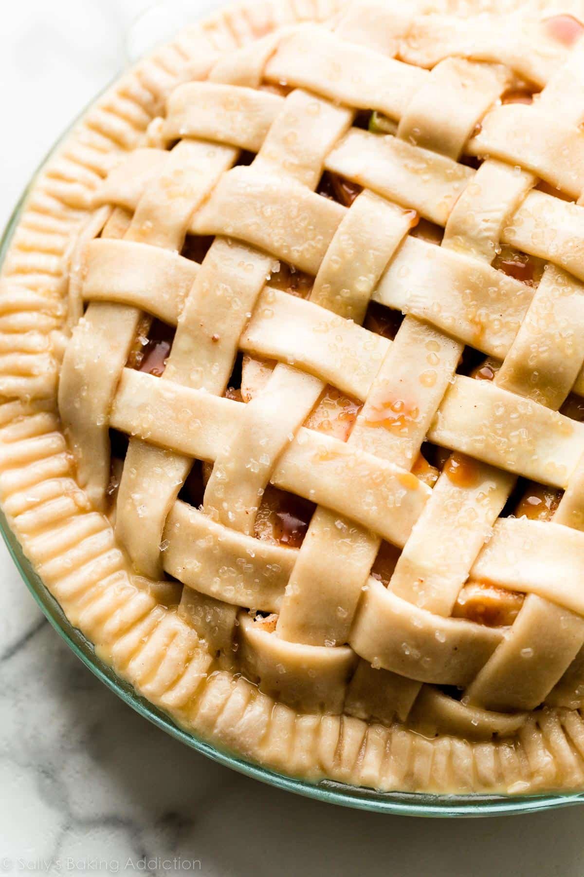unbaked pie with lattice pie crust and crimped edge.