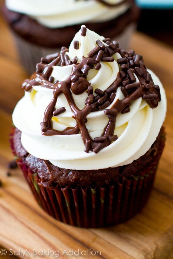 chocolate cupcakes topped with white chocolate frosting and chocolate sprinkles