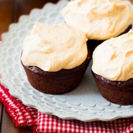 chocolate cupcakes topped with peanut butter Greek yogurt frosting on a white plate