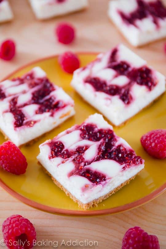 raspberry cheesecake bars on a yellow plate