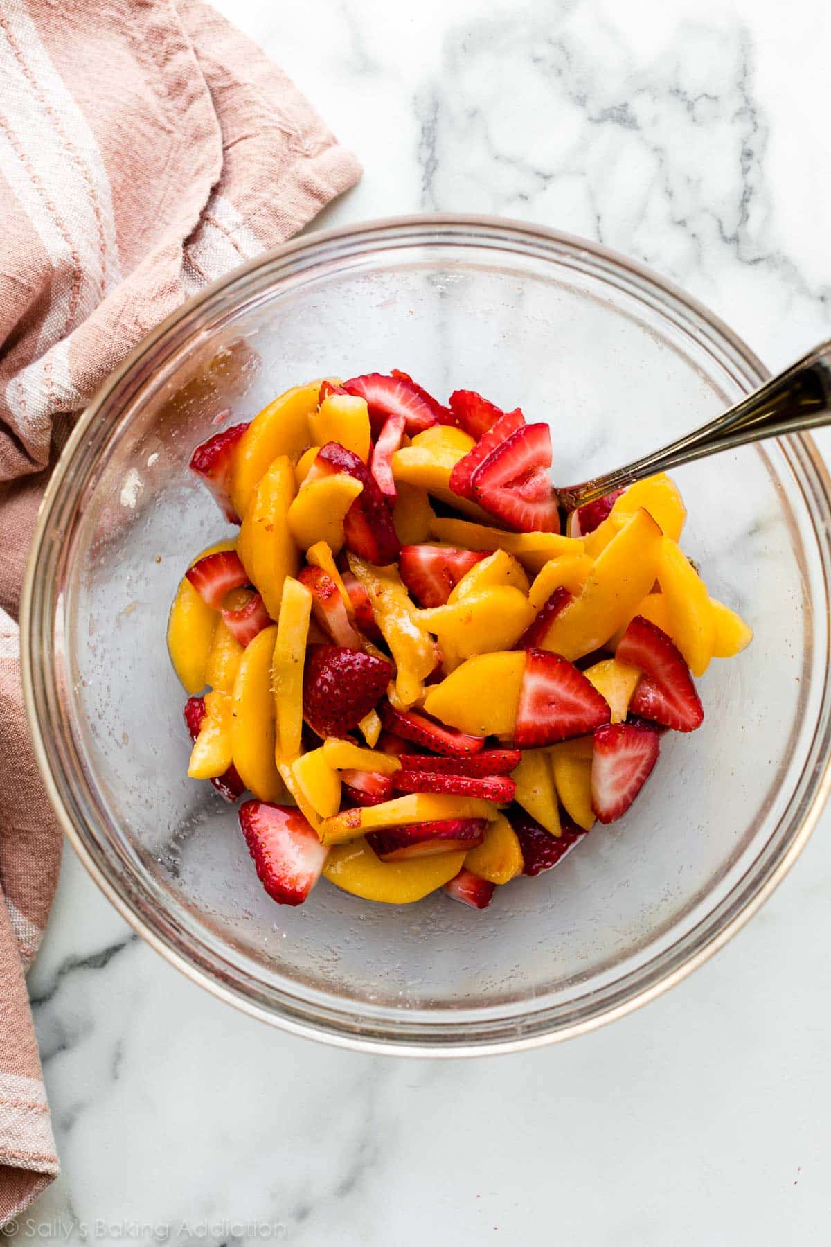 strawberries and peaches in glass bowl