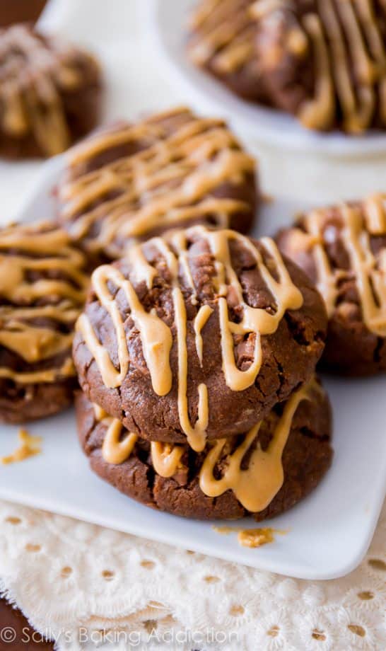 chocolate cookies with peanut butter drizzle on a white plate