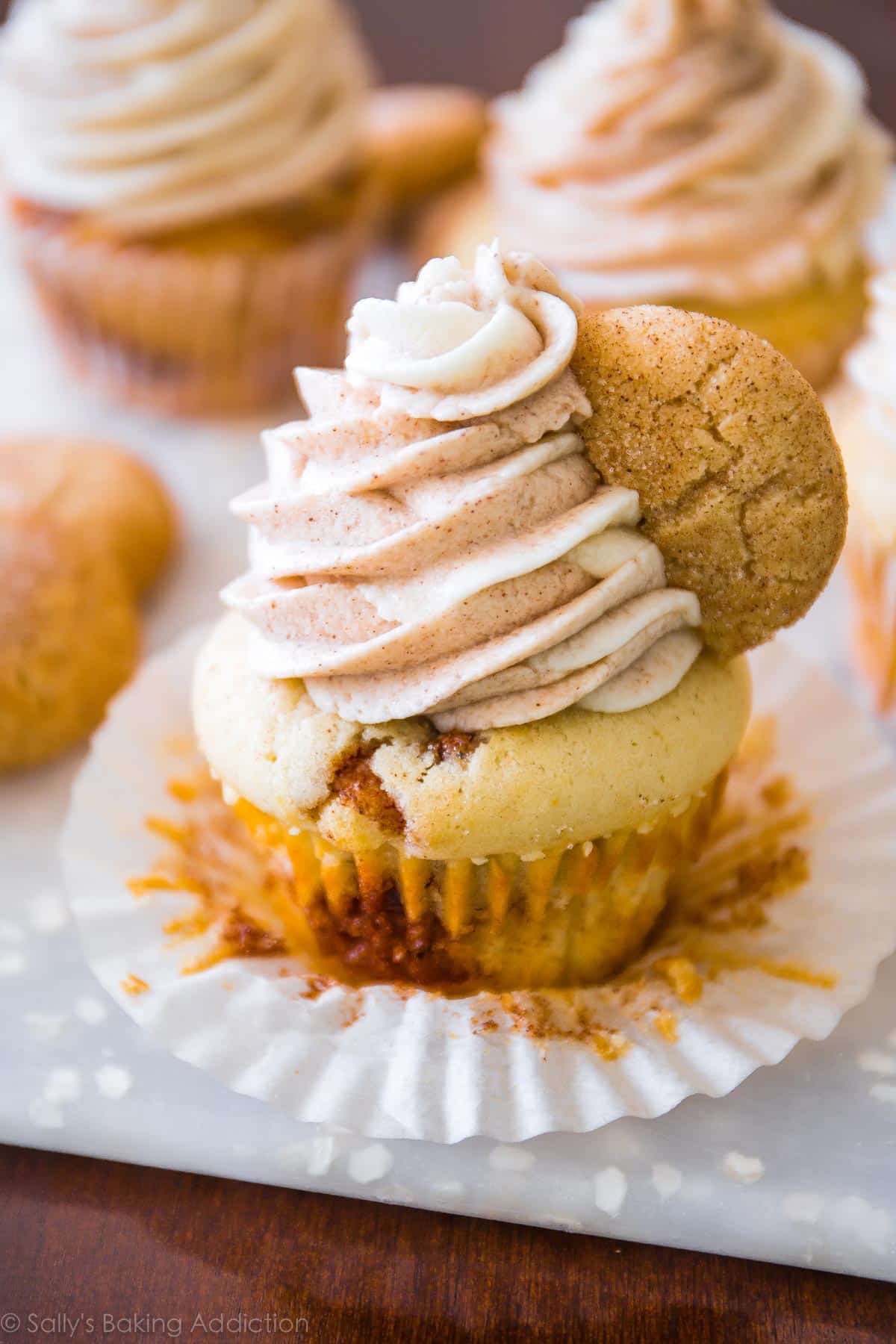 snickerdoodle cupcake topped with cinnamon and vanilla swirl frosting and a snickerdoodle cookie