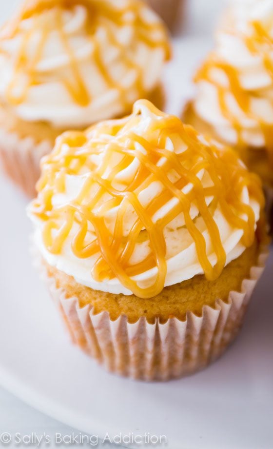 brown sugar cupcakes topped with vanilla frosting and butterscotch drizzle