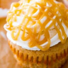 brown sugar cupcake topped with vanilla frosting and butterscotch drizzle