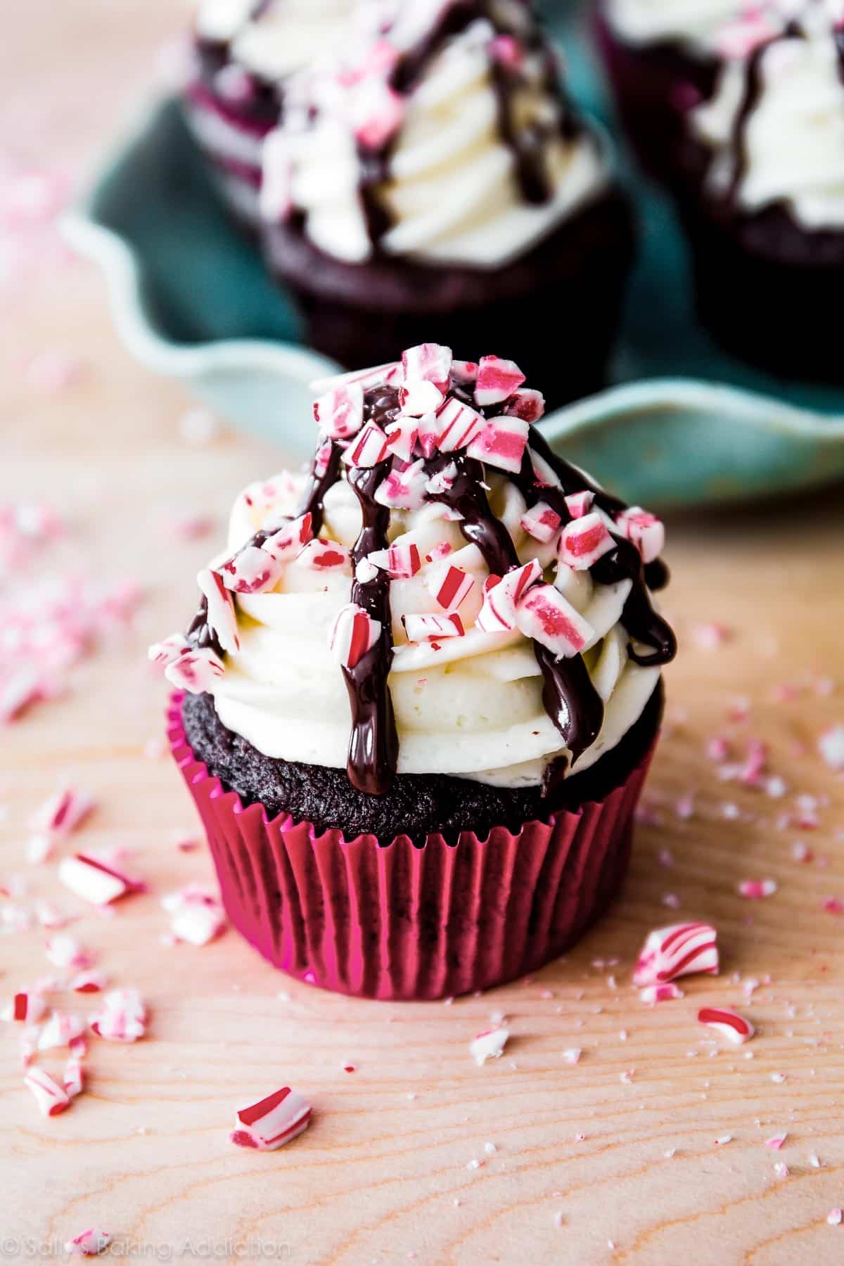 peppermint mocha cupcake with a chocolate drizzle and crushed candy canes