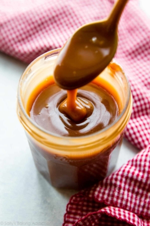 Salted caramel in a glass jar with a spoon
