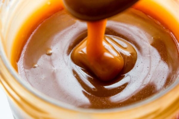 Salted caramel in a glass jar with a spoon