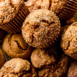 close-up photo of many pumpkin muffins topped with coarse sugar.
