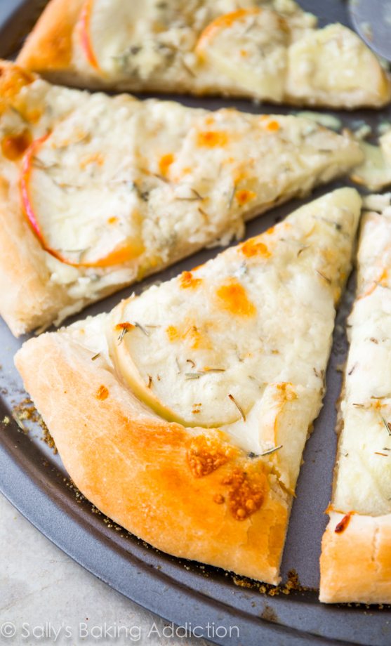 caramelized apple gorgonzola pizza cut into slices on a pizza pan