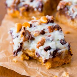 ultimate magic cookie bars with a bite taken from one