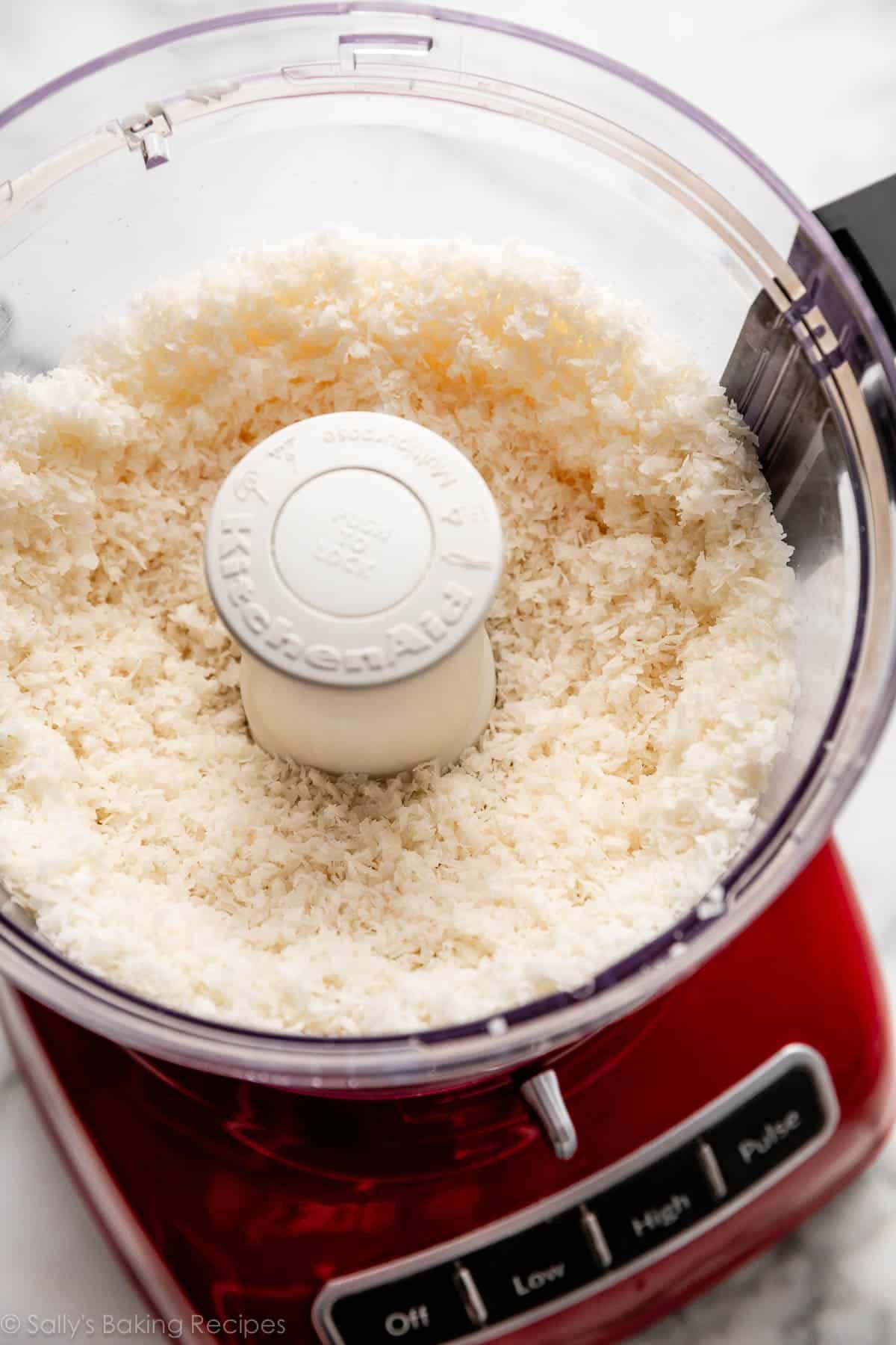 pulsed coconut in red food processor bowl.