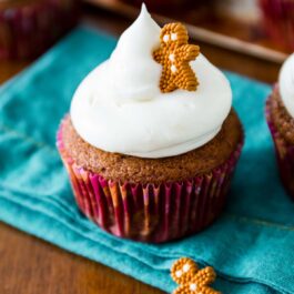 gingerbread cupcakes topped with cream cheese frosting and a decorative gingerbread man candy
