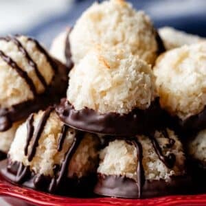 red plate with chocolate dipped coconut macaroons.