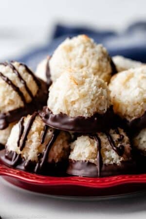 red plate with chocolate dipped coconut macaroons.