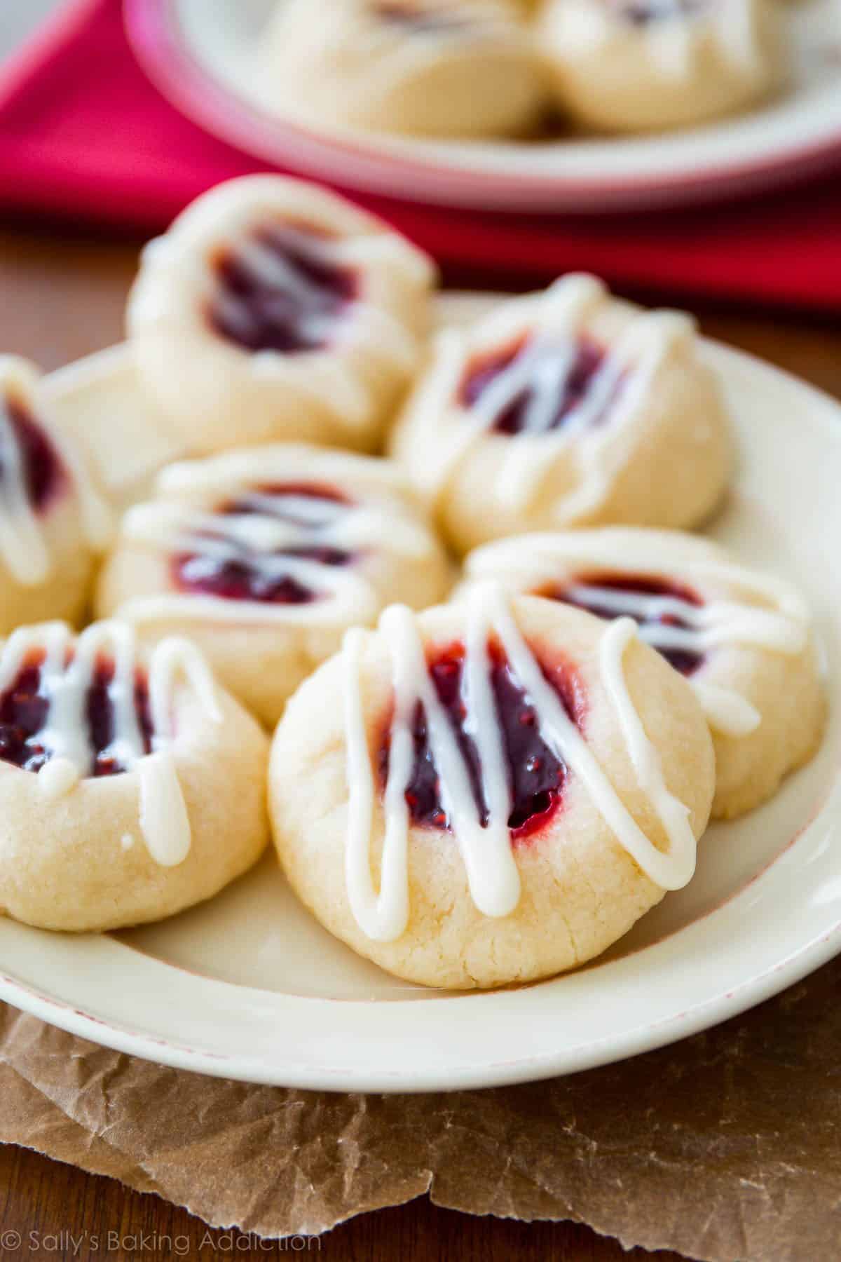 raspberry almond shortbread cookies with vanilla icing on a white plate