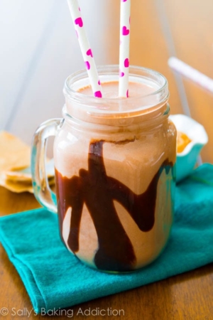 chocolate peanut butter smoothie in a glass mug with straws
