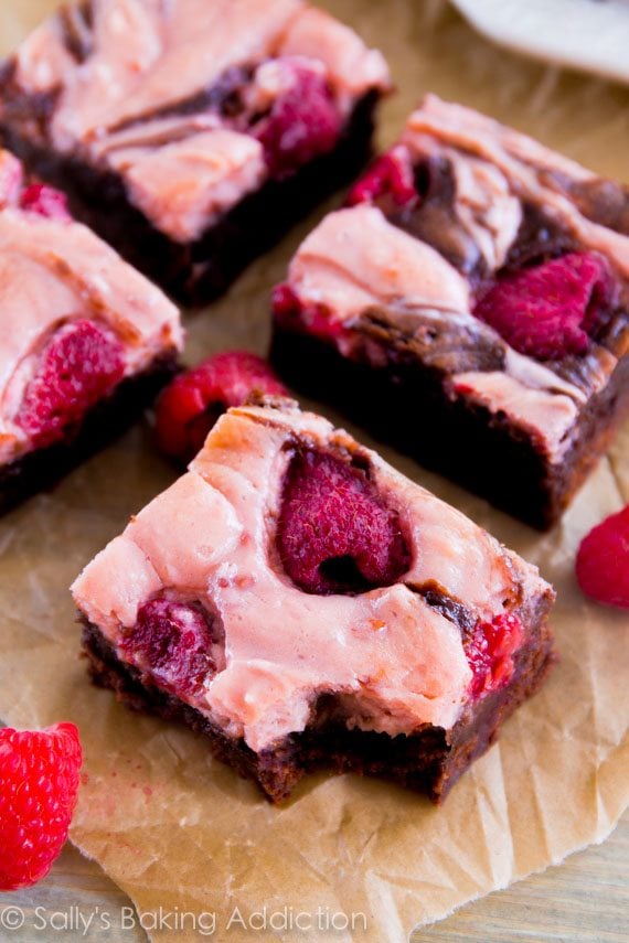 raspberry cheesecake brownies with a bite taken from one