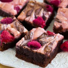 raspberry cheesecake brownies on a white plate