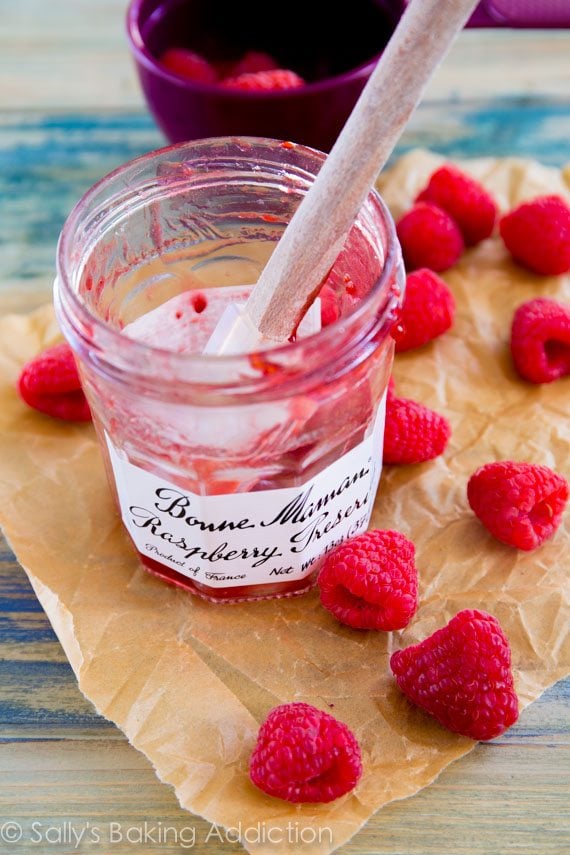 empty jar of raspberry jam with a spatula