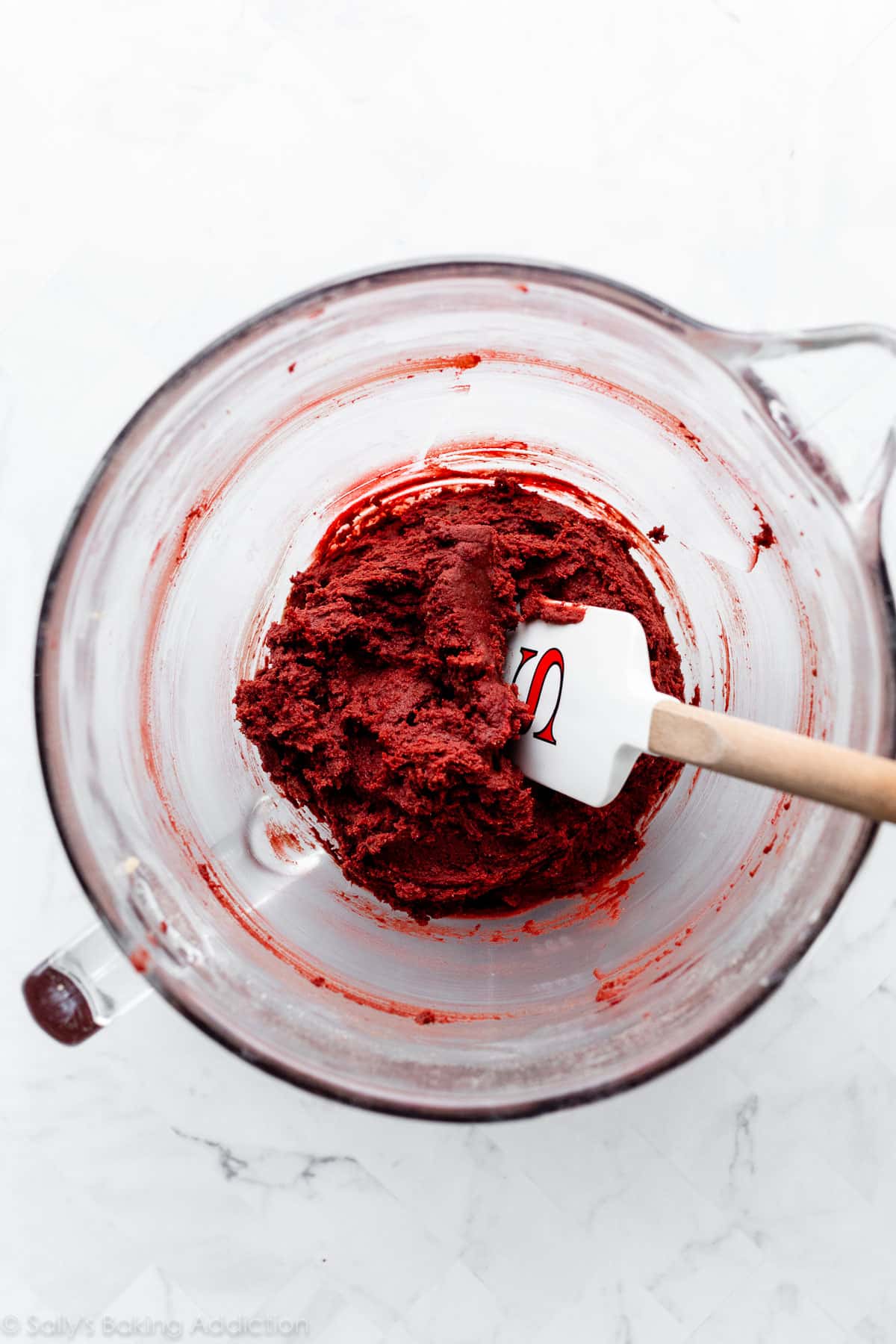 red velvet cookie dough in glass mixing bowl