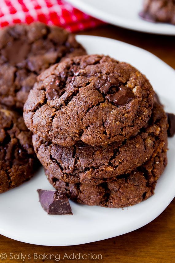 stack of flourless dark chocolate almond butter cookies on a white plate