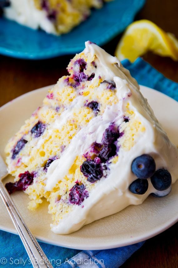Sunshine-sweet lemon layer cake dotted with juicy blueberries and topped with lush cream cheese frosting. Recipe by sallysbakingaddiction.com