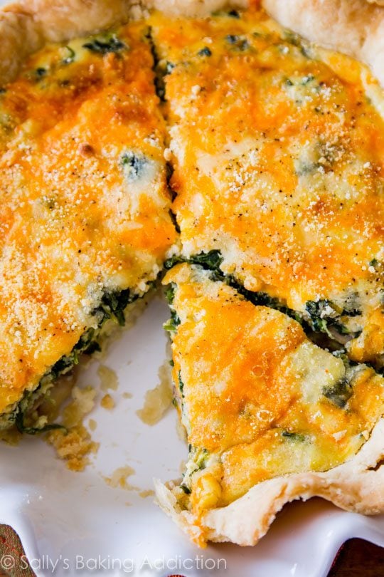 overhead image of cheese spinach quiche in a white pie dish