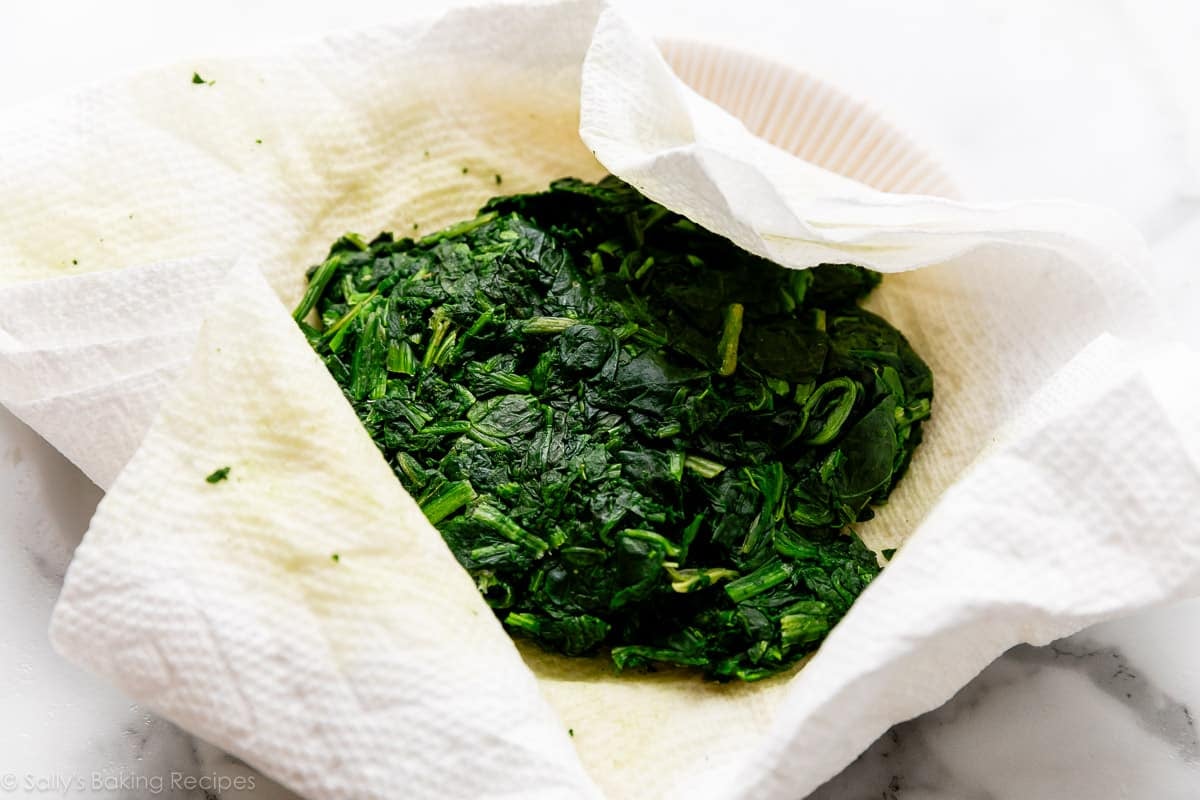blotting spinach with paper towels.