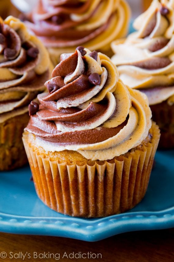 banana chocolate chip cupcakes topped with chocolate peanut butter swirl frosting on a blue plate