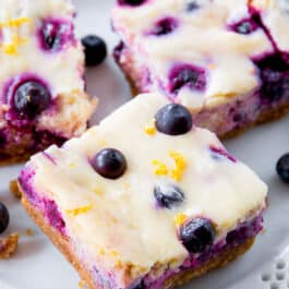 lemon blueberry cheesecake bars on a white plate