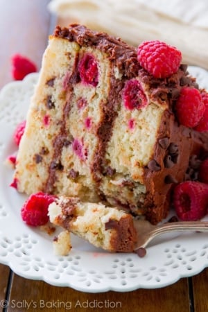 slice of raspberry chocolate chip layer cake on a white plate with a fork