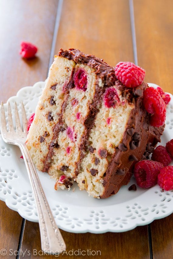 slice of raspberry chocolate chip layer cake on a white plate with a fork