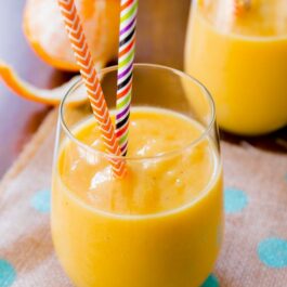 sunshine smoothie in a glass with straws