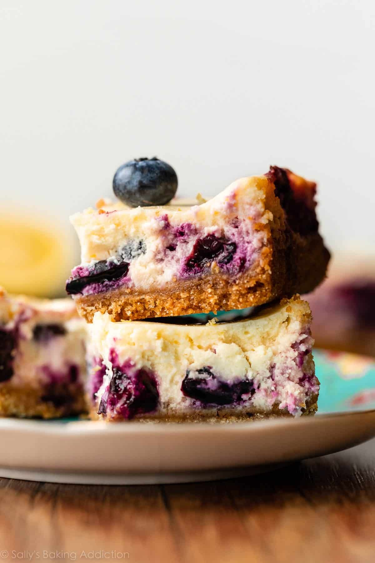 stack of two lemon cheesecake bars with blueberries.