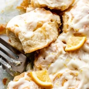 lemon sweet rolls with lemon cream cheese icing in glass dish.