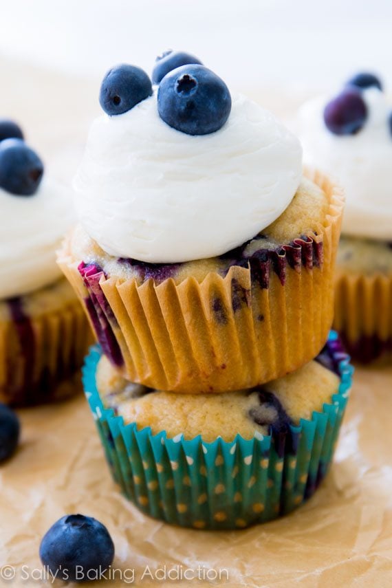 stack of blueberry cupcakes topped with cream cheese frosting and fresh blueberries