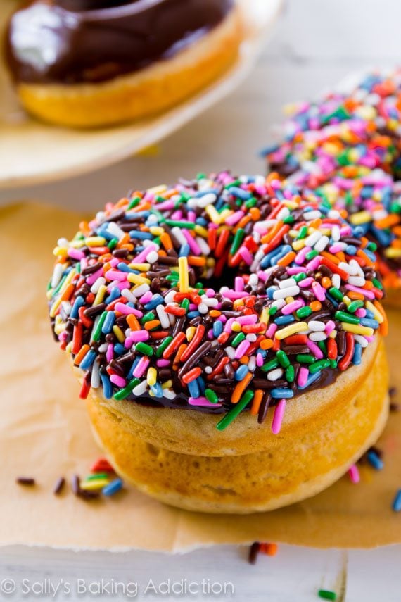stack of chocolate frosted donuts topped with sprinkles