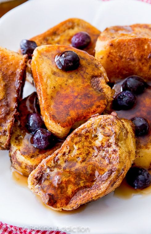 mini french toast bites with maple syrup and blueberries on a white plate