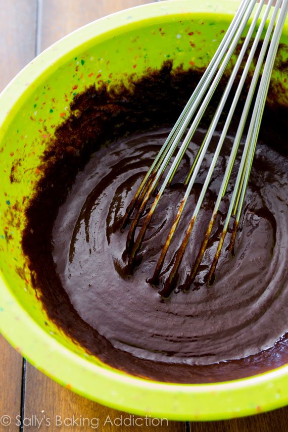 brownie batter in a green bowl with a whisk
