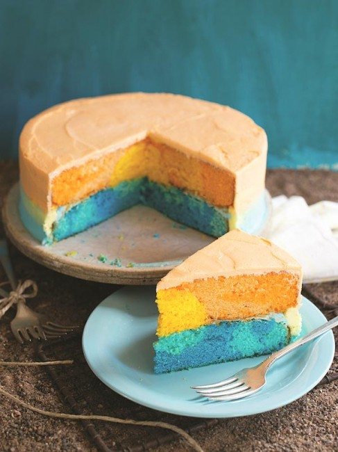 sunset cake on a cake stand and a slice of sunset cake on a blue plate with a fork