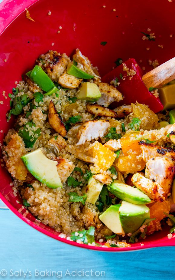 citrus chicken quinoa salad in a red mixing bowl