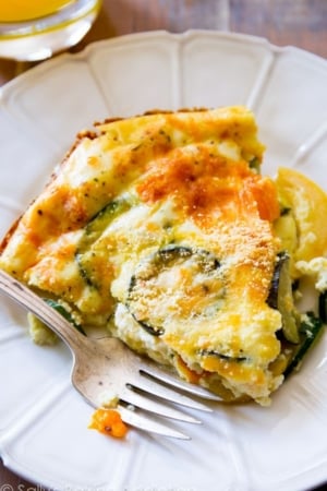 slice of crustless veggie quiche on a white plate with a fork