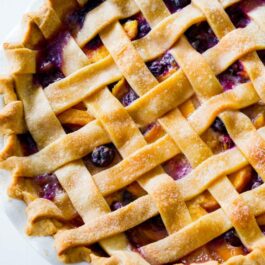 blueberry peach pie in a white pie dish