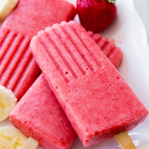 strawberry banana popsicles on a white serving tray