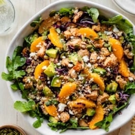 citrus chicken quinoa salad with oranges, pepitas, and avocado.