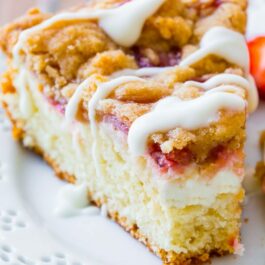 slice of glazed strawberry crumb cake on a white plate