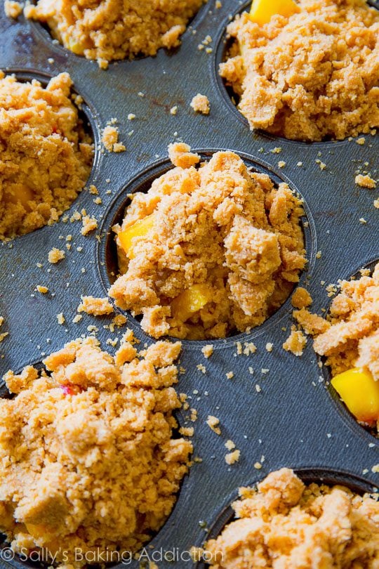 peach streusel muffins in a muffin pan